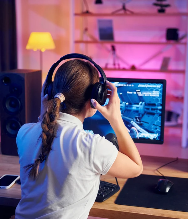 twilight-gaming-addiction-girl-wearing-headphones-sitting-desk-page